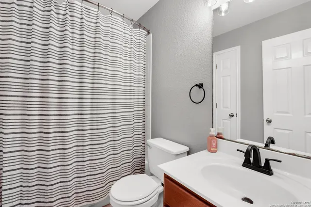 a bathroom with a sink a toilet and mirror