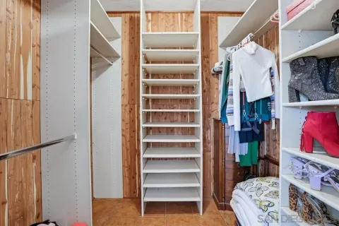 a view of walk in closet with clothes and shoes