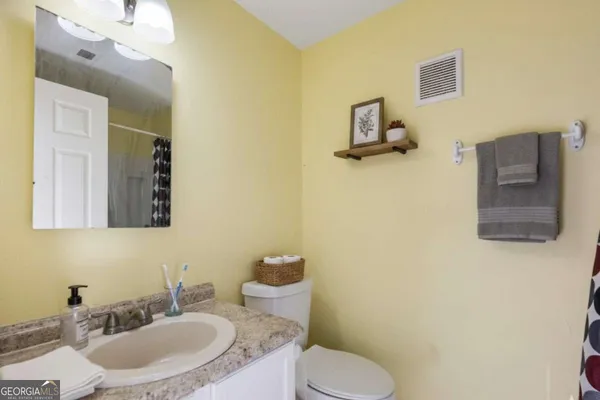 a bathroom with a toilet sink and mirror