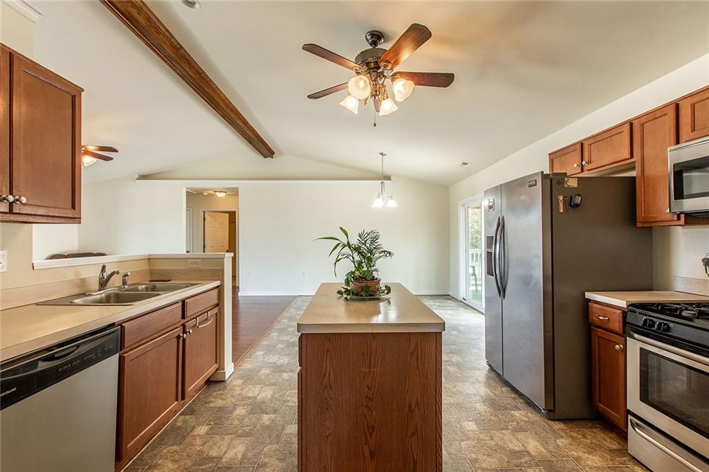9481 Sturgeon Point Road Charles City, VA 23030 - Photo 7 of 44 a kitchen with stainless steel appliances granite countertop a refrigerator a sink dishwasher a stove and a dining table