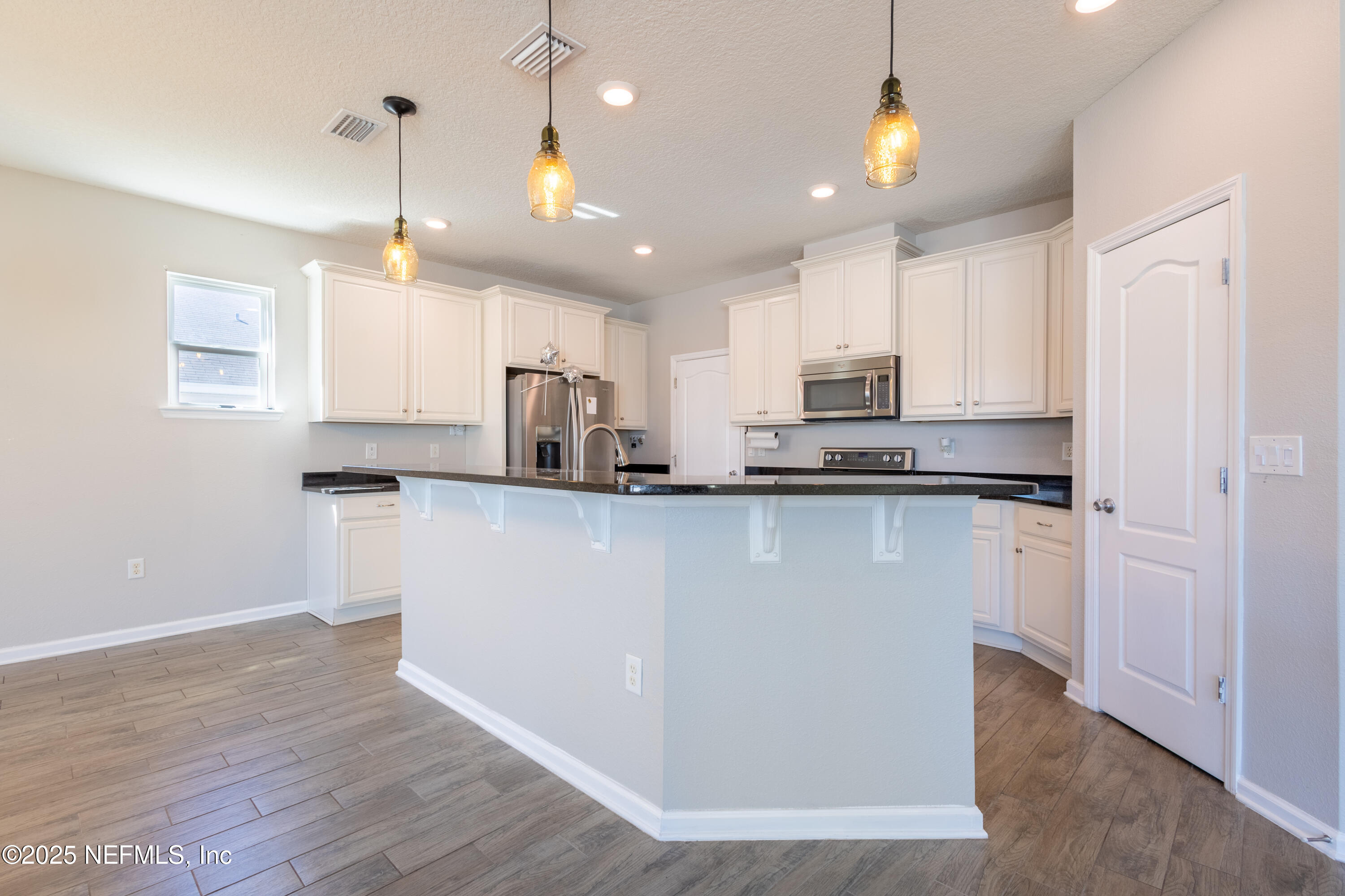 68 Redland Way Jacksonville, FL 32218 - Photo 16 of 40 a kitchen with kitchen island white cabinets and refrigerator