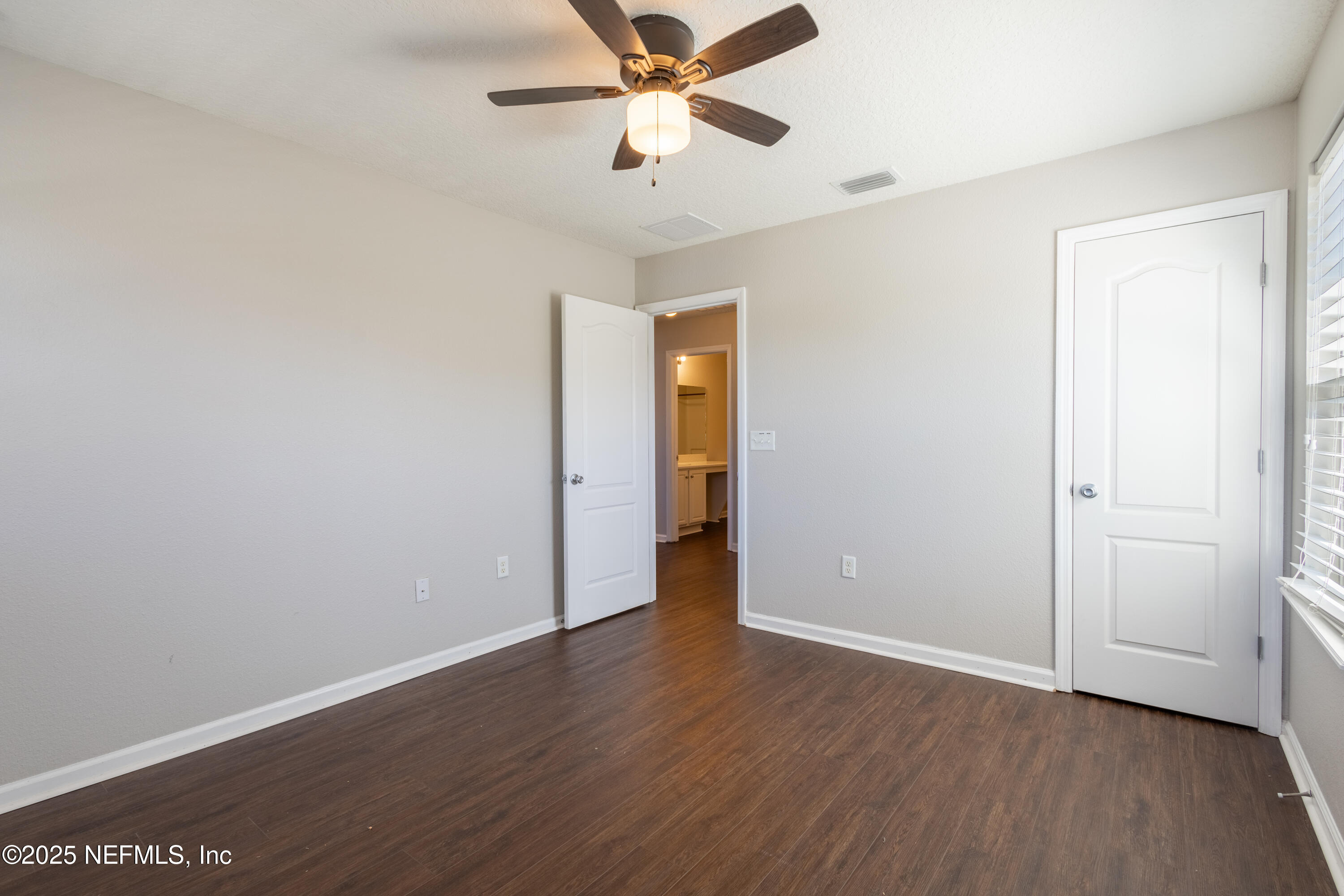 68 Redland Way Jacksonville, FL 32218 - Photo 27 of 40 an empty room with wooden floor ceiling fan and windows