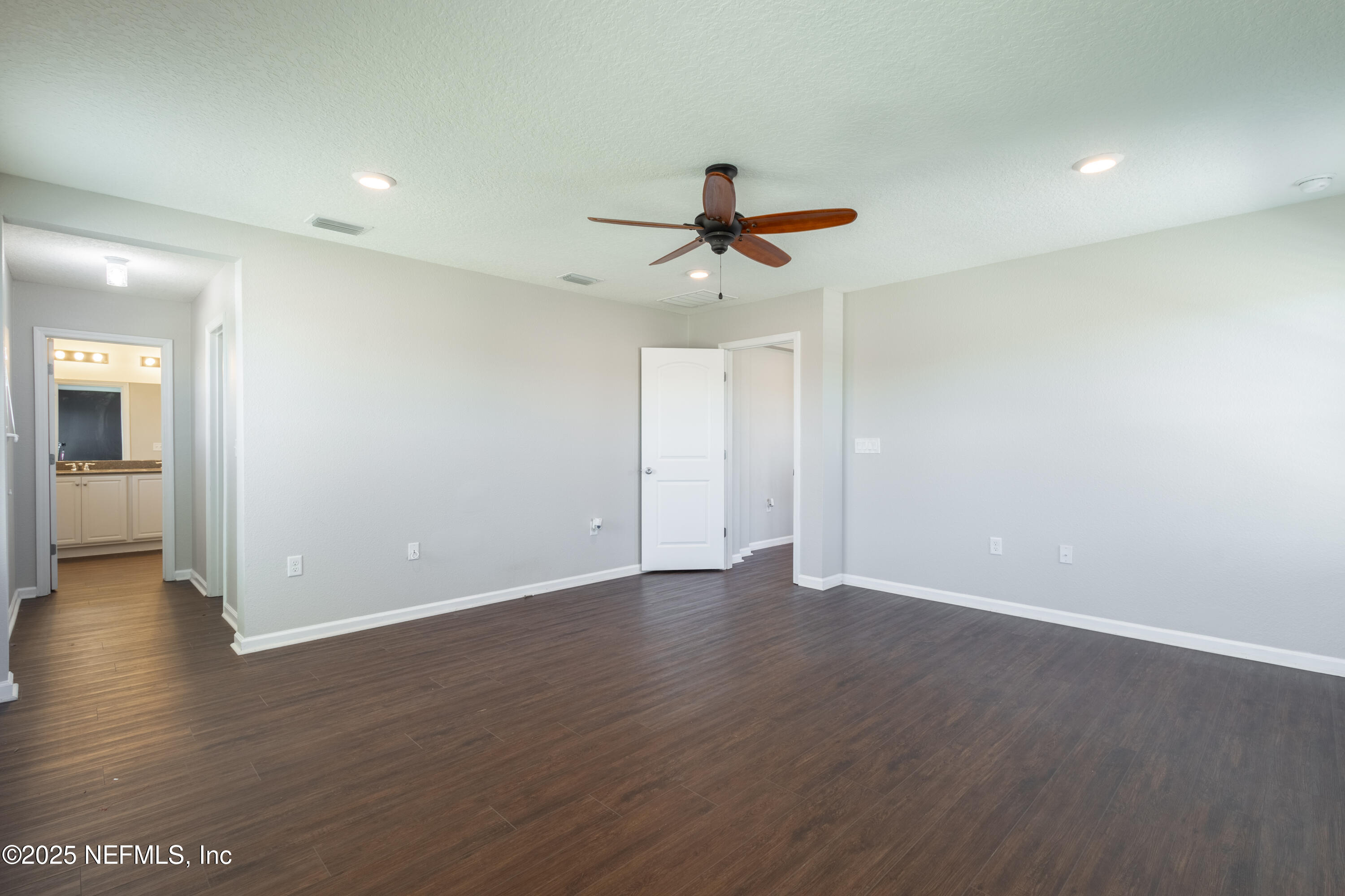 68 Redland Way Jacksonville, FL 32218 - Photo 32 of 40 a view of an empty room with wooden floor and a ceiling fan