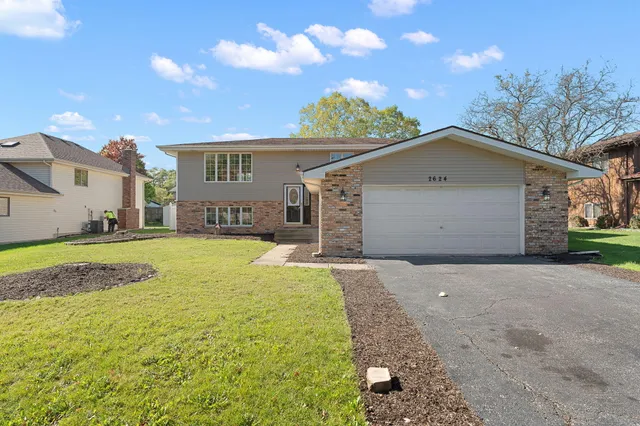 a view of a house with a yard and garage