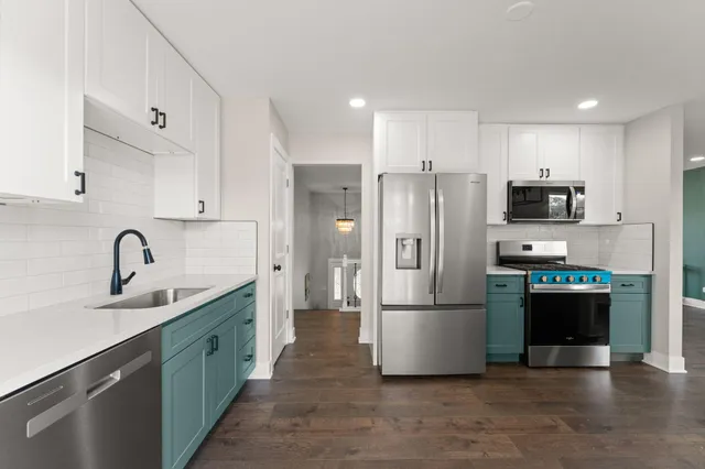 a kitchen with stainless steel appliances granite countertop a refrigerator sink and stove