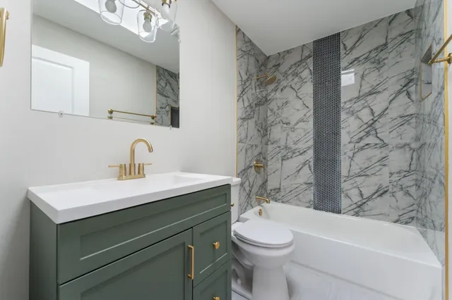 a bathroom with a sink a toilet and shower