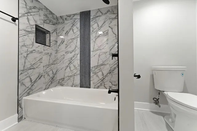 a white bath tub sitting next to a white toilet