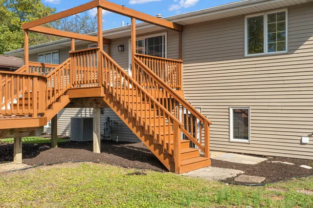 a view of house with wooden stairs and a small yard