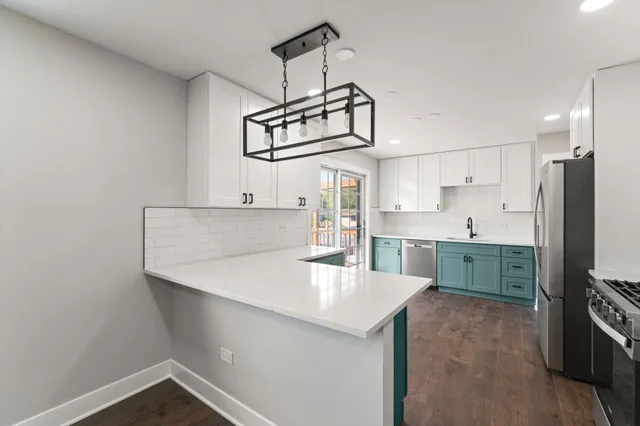 a kitchen with kitchen island a counter top space stainless steel appliances and cabinets