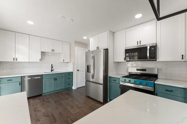 a kitchen with granite countertop a refrigerator and a stove top oven