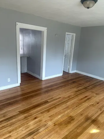 a view of an empty room with wooden floor