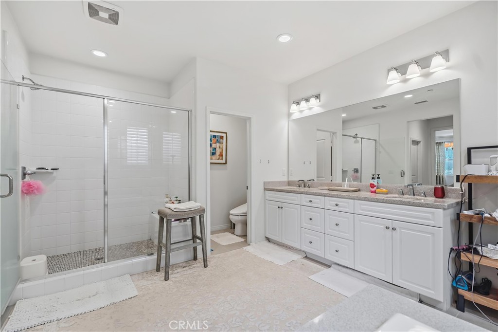 3380 Pine Ridge Loop Ontario, CA 91761 - Photo 22 of 37 a spacious bathroom with a granite countertop sink a toilet and a mirror