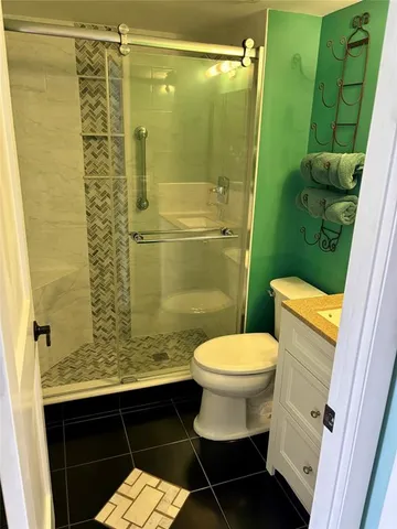 a bathroom with a granite countertop toilet sink and mirror