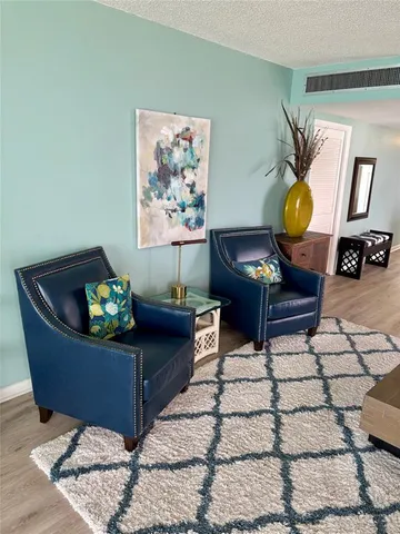 a living room with wooden floor and a flat screen tv