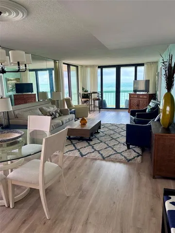 a living room with furniture a large window and a table