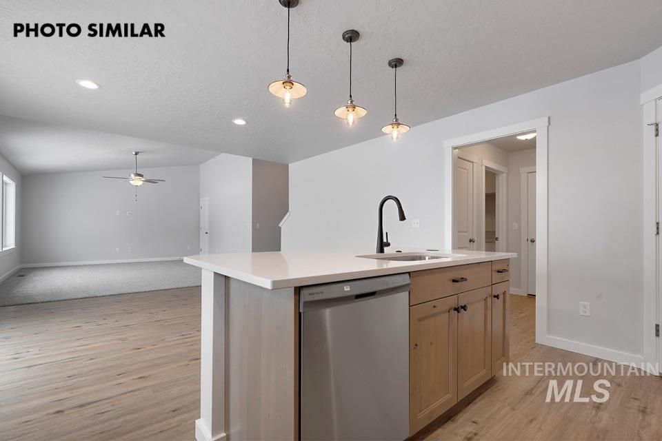 1644 Haystack Emmett, ID 83617 - Photo 12 of 33 Kitchen island featuring a stainless steel dishwasher, undermount sink with a matte black faucet, and pendant lighting