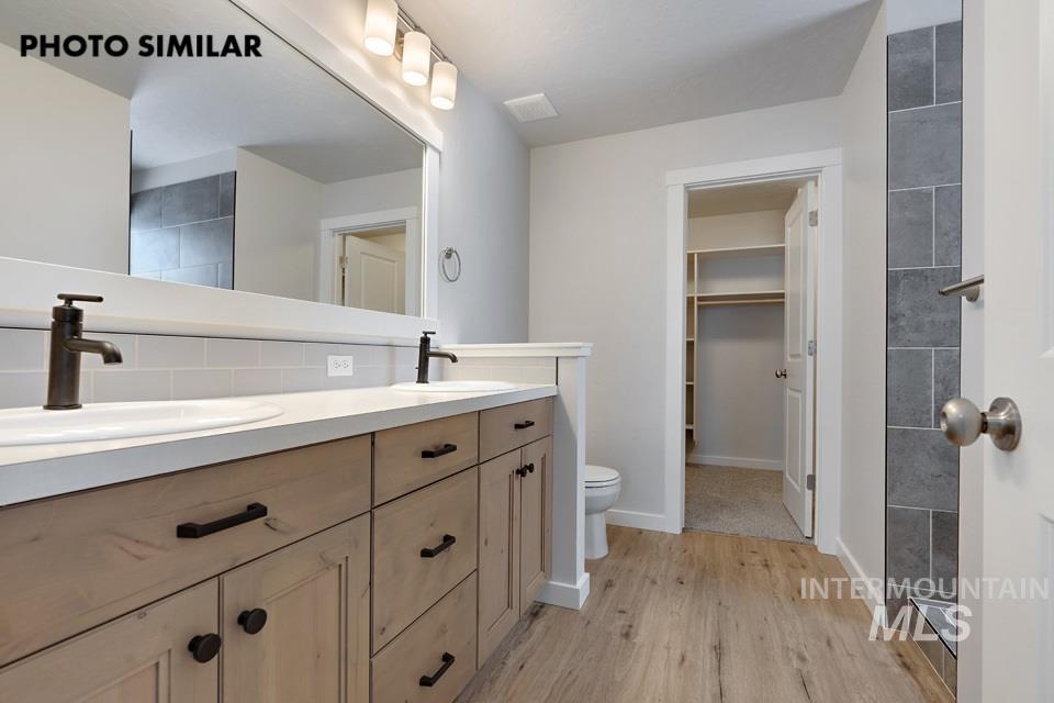1644 Haystack Emmett, ID 83617 - Photo 18 of 33 Dual vanity with wood-finish cabinetry, white countertops, and undermount sinks