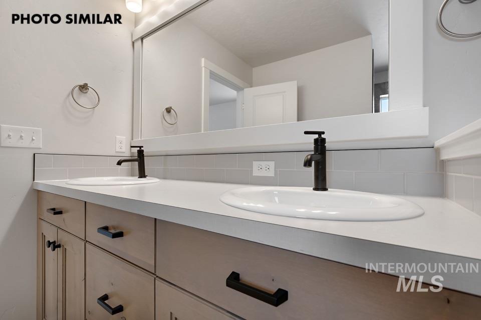 1644 Haystack Emmett, ID 83617 - Photo 19 of 33 Double vanity with light wood-finish cabinetry, white countertops, and matte black fixtures