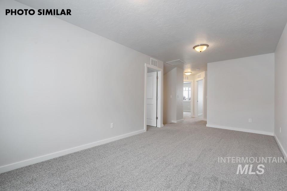1644 Haystack Emmett, ID 83617 - Photo 22 of 33 Spacious room featuring neutral carpeting, light gray walls, white trim, and a semi-flush ceiling light fixture