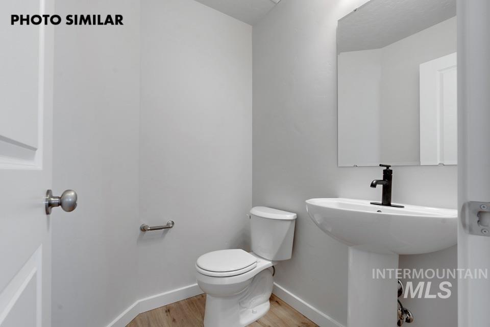 1644 Haystack Emmett, ID 83617 - Photo 24 of 33 Pedestal sink with a matte black faucet, wall-mounted mirror, and wood-finish flooring