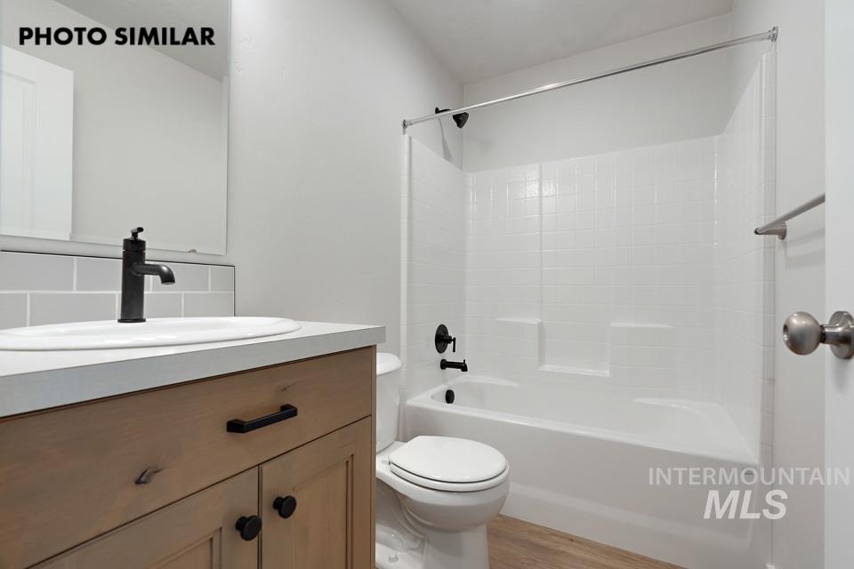 1644 Haystack Emmett, ID 83617 - Photo 30 of 33 Bathroom featuring a wood-finish vanity with black hardware, a white countertop, and an undermount sink with a matte black faucet