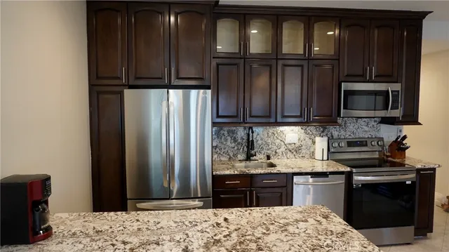 a kitchen with stainless steel appliances granite countertop a refrigerator stove and microwave
