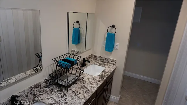 a bathroom with a granite countertop sink and a mirror