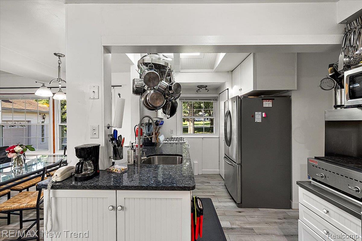 1450 Lenox Road Bloomfield Hills, MI 48304 - Photo 24 of 79 Kitchen featuring wood-finish flooring, stainless steel appliances, white cabinetry, and a dark stone-finish countertop