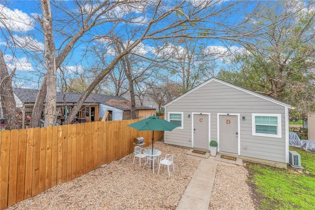 a backyard of a house with table and chairs
