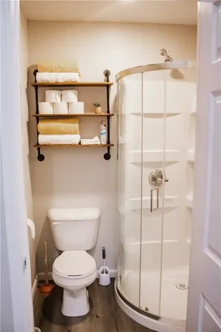 a bathroom with a toilet and a shower