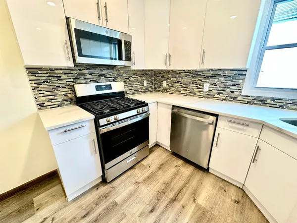 a kitchen with stainless steel appliances granite countertop a stove and a microwave