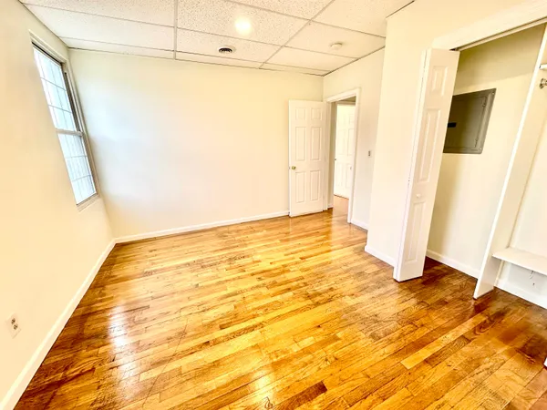 a view of a room with wooden floor and door