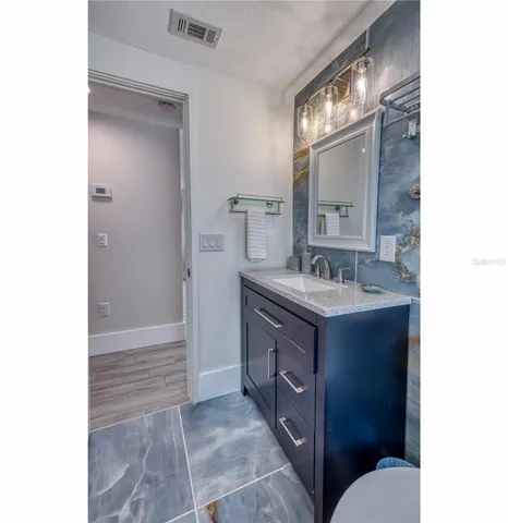 a bathroom with a sink vanity granite and a mirror