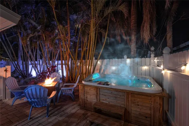 a view of a backyard with table and chairs with wooden fence