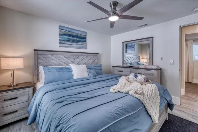 a bedroom with a bed and a lamp on a dresser