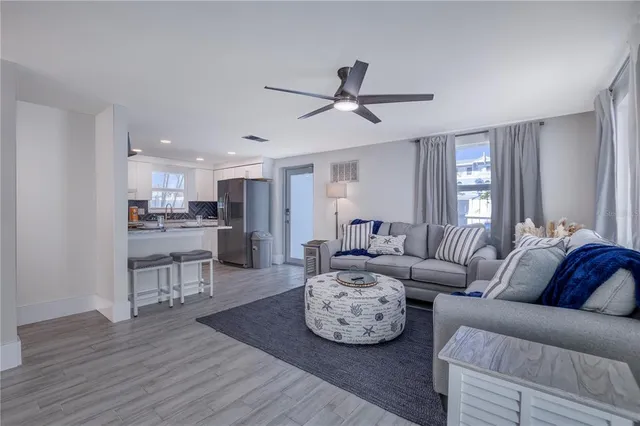 a living room with furniture and a view of kitchen