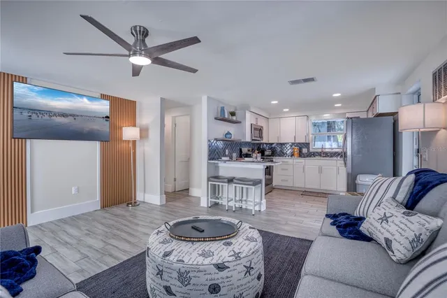 a living room with furniture and a view of kitchen