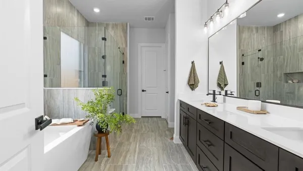 a bathroom with a tub sink vanity granite and shower