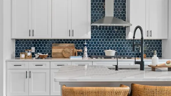 a kitchen with white cabinets and sink