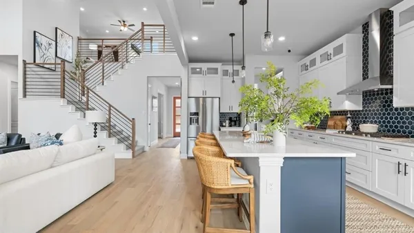 a large white kitchen with lots of counter space a sink and appliances