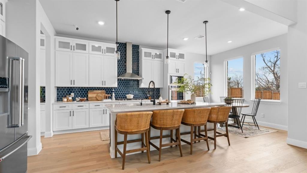 1633 Keneipp Road Carrollton, TX 75006 - Photo 5 of 18 a kitchen with stainless steel appliances kitchen island granite countertop a table chairs and a refrigerator