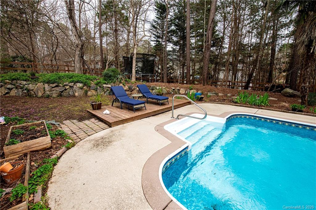 11135 Scullers Run Tega Cay, SC 29708 - Photo 29 of 33 a view of swimming pool with seating space and trees in the background
