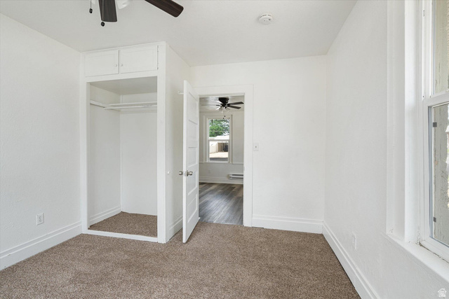370 West 800 South Beaver, UT 84713 - Photo 5 of 15 Carpeted room featuring a built-in closet with upper cabinetry, a window with white trim, and a ceiling fan