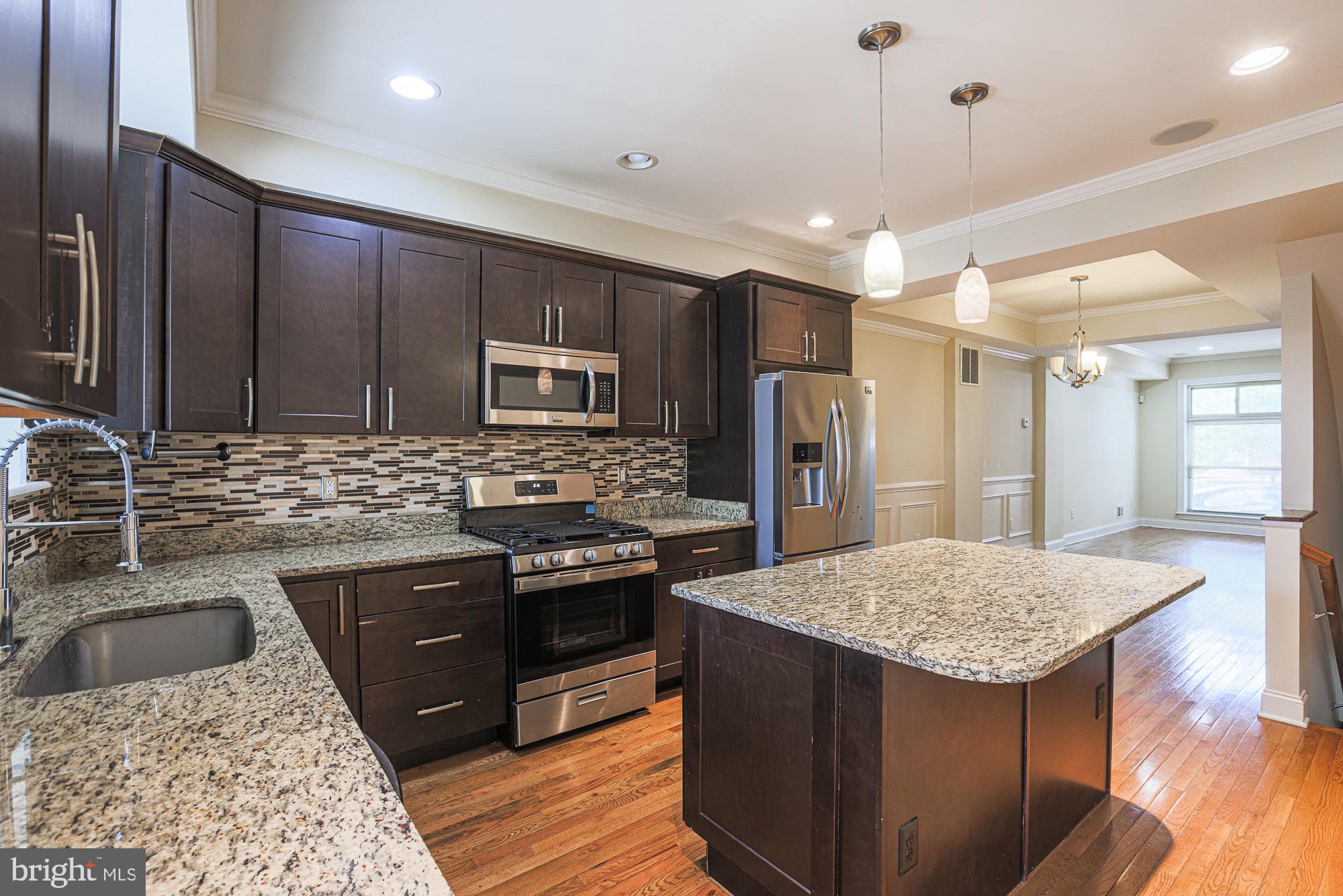 122 South Potomac Street Baltimore, MD 21224 - Photo 11 of 31 a kitchen with stainless steel appliances granite countertop a sink stove and refrigerator