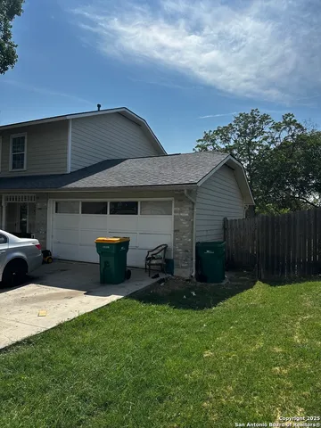 a view of a backyard with couches plants and large trees
