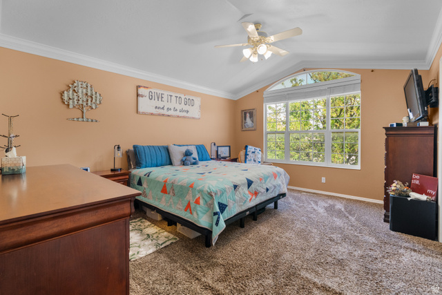 5727 South 3550th Street West Roy, UT 84067 - Photo 8 of 49 Master bedroom featuring vaulted ceilings, crown molding, a multi-pane arched window, and plush carpet flooring
