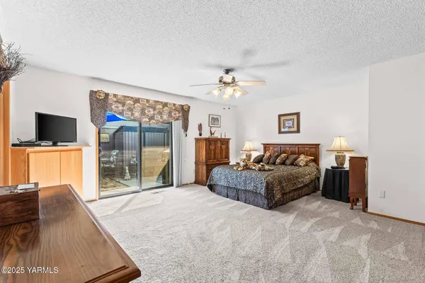 a spacious bedroom with a bed and a flat screen tv