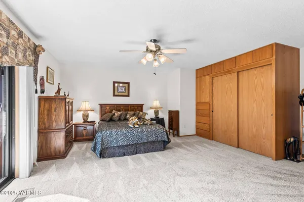 a spacious bedroom with a bed and a refrigerator