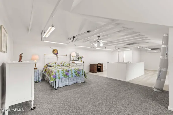 a spacious bedroom with a bed and a chandelier