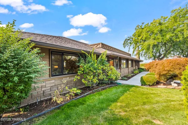 a front view of a house with a garden and plants